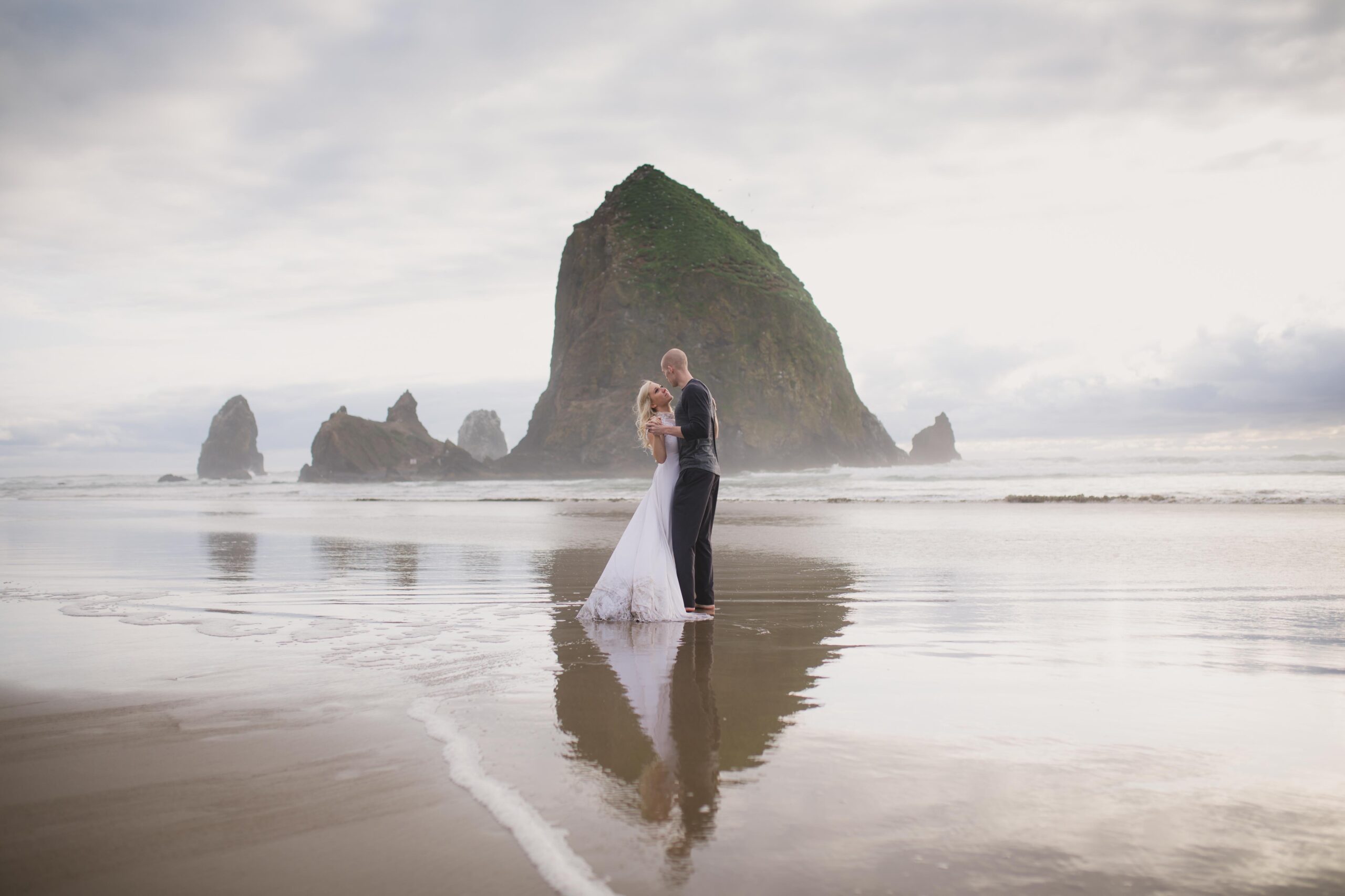Oregon Coast wedding in Cannon Beach, groom holding the bride in front of Haystack Rock